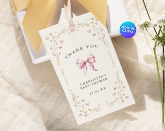 Könnte beinhalten: Ein weißes Dankeschön-Etikett mit floralem Rand und einer rosa Schleife. Der Text auf dem Etikett lautet "Danke, Baby Shower von Charlotte, 27.05.XX".
