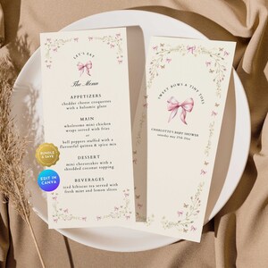 Może przedstawiać: Drukowana karta menu na baby shower z kwiatową ramką i różową kokardką. Menu zawiera przystawki, danie główne, deser i napoje. Tekst na karcie brzmi "Let's Eat" i "Sweet Bows & Tiny Toes".