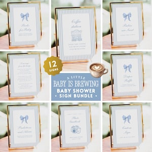 May include: A set of twelve baby shower signs in gold frames featuring blue striped borders and light blue bow illustrations. The signs include text such as Books for Baby, Coffee station, Babies are Sweet, Diaper Raffle, and A Little Baby Is Brewing.