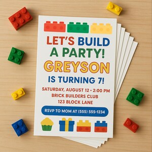 May include: A stack of white invitation cards with colourful block-themed graphics and text that reads "LET'S BUILD A PARTY! GREYSON IS TURNING 7!" Scattered around are red, green, yellow, and blue toy blocks.