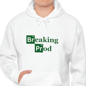 Op de afbeelding: Witte hoodie met een groene afbeelding van het Breaking Bad-logo, met de tekst "Breaking Bad" en de chemische symbolen voor de elementen broom en lithium.