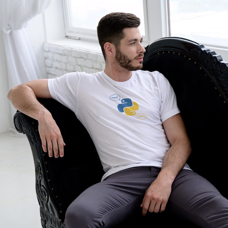 May include: White t-shirt featuring the Python programming language logo in blue and yellow, with speech bubbles saying "boss" and "yesss". The shirt is worn with gray pants.
