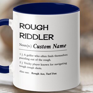May include: White ceramic coffee mug with a blue rim. The mug features a definition of "Rough Riddler" with the text "Custom Name" in place of the definition. The definition reads: "A golfer who often finds themselves puzzling out of the rough. Tricky player known for navigating tough rough shots. Also see: Rough Ace, Turf Fox."