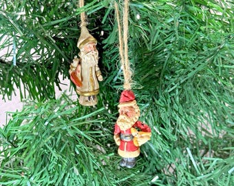 2 Department 56 Poliwoggs Santa Christmas Ornaments: One with Sailboat & One with Clown Doll
