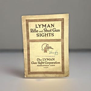 May include: Vintage Lyman Rifle and Shot Gun Sights brochure. The brochure is tan with a brown border and features the text "LYMAN Rifle and Shot Gun SIGHTS". The brochure also includes the text "Che LYMAN Gun Sight Corporation MIDDLEFIELD, CONN. U.S.A."