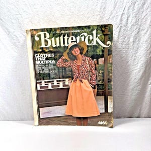 May include: A white ceramic mug with a black handle and the text "But First, Coffee" in a black, handwritten-style font. The mug is on a white surface.