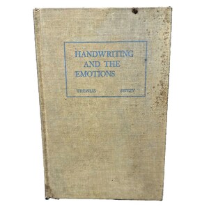 May include: A vintage book titled "Handwriting and the Emotions" by Thewlis and Swezy. The book cover is a light beige color with a blue title and author names.