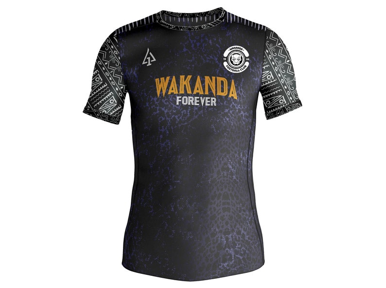 May include: Black and purple soccer jersey with a white tribal pattern on the sleeves. The jersey has the words "Wakanda Forever" and a logo with a black panther head.
