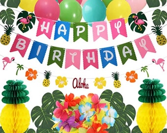 May include: Tropical luau party decorations with a happy birthday banner, green and yellow pineapples, pink flamingos, green leaves, and colorful flowers.