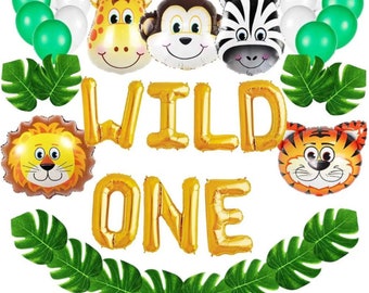 Può includere: Palloncini in lamina d'oro che compongono la scritta "WILD ONE" con decorazioni di palloncini a forma di animali della giungla, tra cui un leone, una tigre, una zebra, una giraffa e una scimmia. Una ghirlanda di foglie verdi circonda i palloncini.