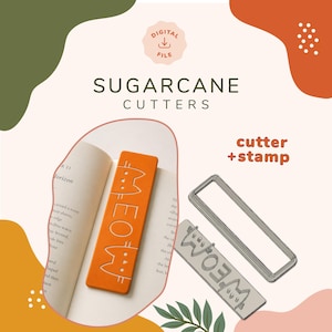 Puede incluir: Un archivo digital para Sugarcane Cutters que incluye un cortador de galletas rectangular y un sello a juego. El sello crea un diseño de gato con el texto MEOW. Se muestra una galleta rectangular naranja con el diseño de gato en un libro abierto.