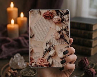 Peut inclure: Une coque de téléphone transparente avec un motif de pages de livres anciens et de roses séchées roses et crème. La coque est tenue dans une main avec du vernis à ongles noir, avec des bougies allumées et des livres en arrière-plan. Un accessoire de téléphone décoratif et unique.