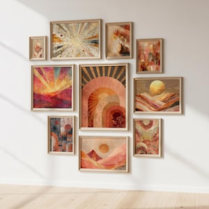 Può includere: Una collezione di stampe artistiche incorniciate con una calda tavolozza di colori terrosi. Le opere d'arte presentano paesaggi astratti, disegni a raggi di sole ed elementi celesti in tonalità arancioni, rosa e oro. Le cornici sono di colore legno chiaro, creando un muro di galleria coeso.