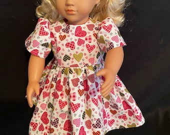 Vestido de algodón hecho a mano para muñeca de 18 pulgadas. Estampado de corazones en rojo, rosa y oro metalizado.