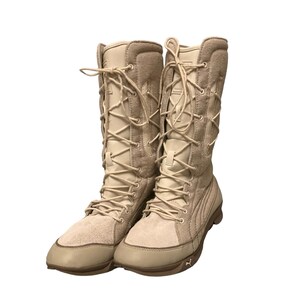 May include: A pair of tan suede high-top boots with lace-up closures. The boots have a thick rubber sole and a padded ankle collar.