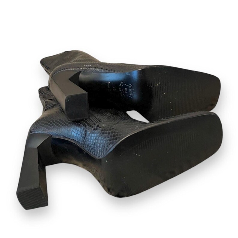 May include: A pair of black snakeskin heeled boots with a square toe. The boots have a chunky heel and a zipper on the back.