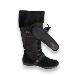 May include: Black knee-high winter boots with a lace-up front and a faux fur cuff. The boots have a black insole with the word "TREAD" printed on it.