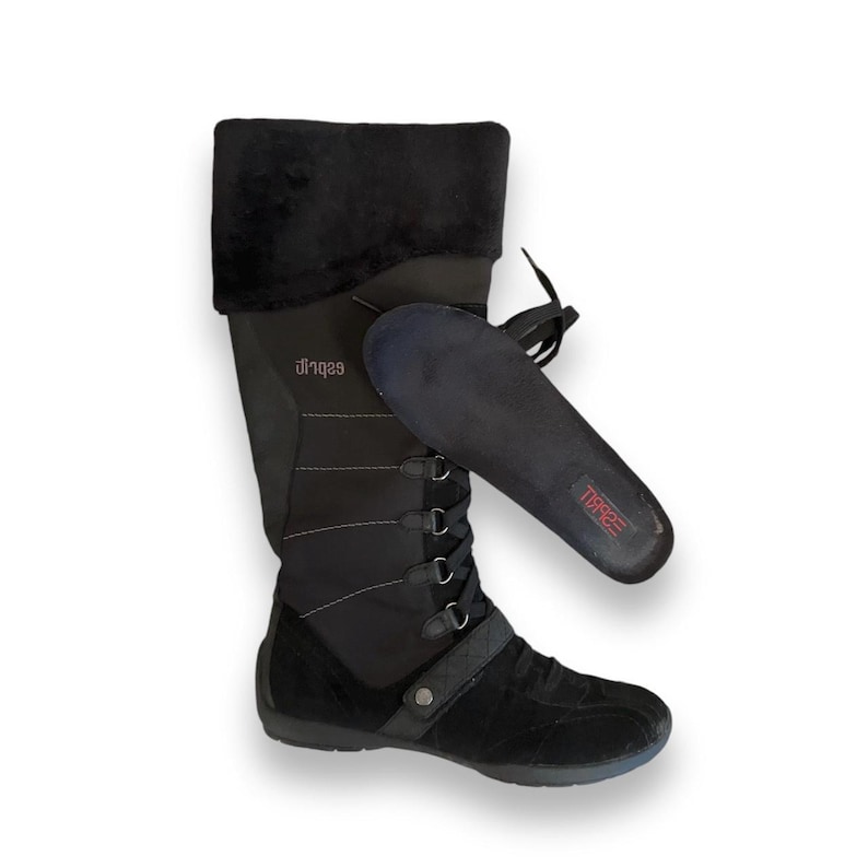 May include: Black knee-high winter boots with a lace-up front and a faux fur cuff. The boots have a black insole with the word "TREAD" printed on it.