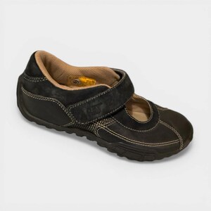 May include: Black leather Mary Jane style shoe with a hook and loop strap. The shoe has a brown interior and white stitching. The sole is black and textured. The shoe has the CAT logo on the strap.