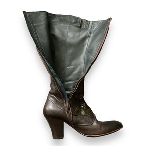 May include: Brown leather knee-high boots with a zipper up the back and a chunky heel.