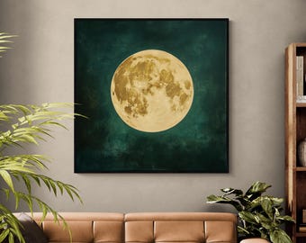 May include: A framed square art print featuring a full moon. The moon is a golden yellow color with detailed surface features, set against a dark teal background. The artwork is displayed above a brown leather sofa, with plants in the foreground.
