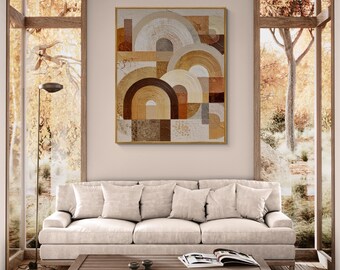 Puede incluir: Arte mural abstracto con un diseño geométrico de formas de arco en tonos marrón, beige y blanco. La obra de arte está enmarcada en dorado y cuelga sobre un sofá color crema. La habitación tiene grandes ventanas.