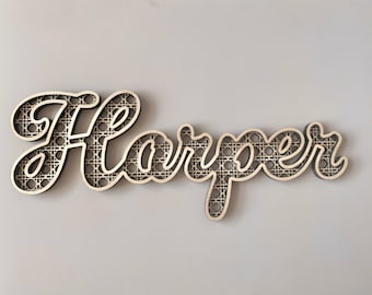 May include: Wooden sign spelling "Harper" in a cursive font. The letters are light-colored with a woven pattern inside, set against a darker outline. The sign is designed to be mounted on a wall.
