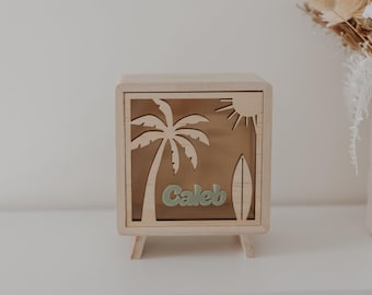 Hucha de madera personalizada con palmera, tabla de surf y sol.