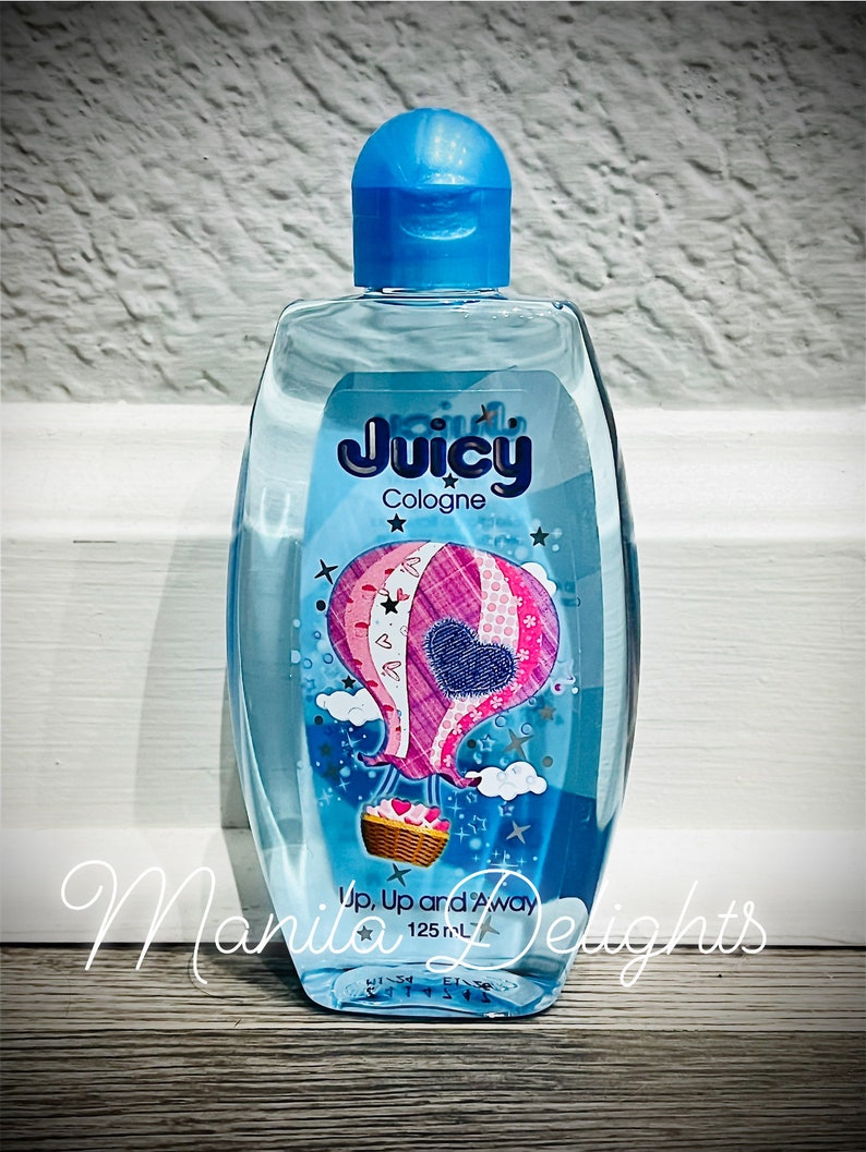 May include: A clear blue bottle of Juicy Cologne with a hot air balloon design. The bottle is 125 ml and says "Up, Up and Away" on the label.