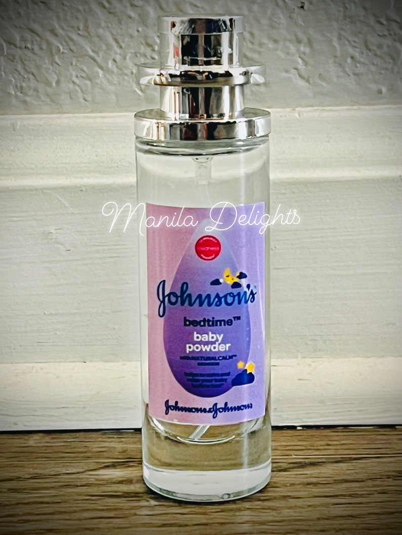 May include: A clear glass bottle with a silver spray nozzle and a purple and yellow label that reads "Johnson's bedtime baby powder with natural calm".