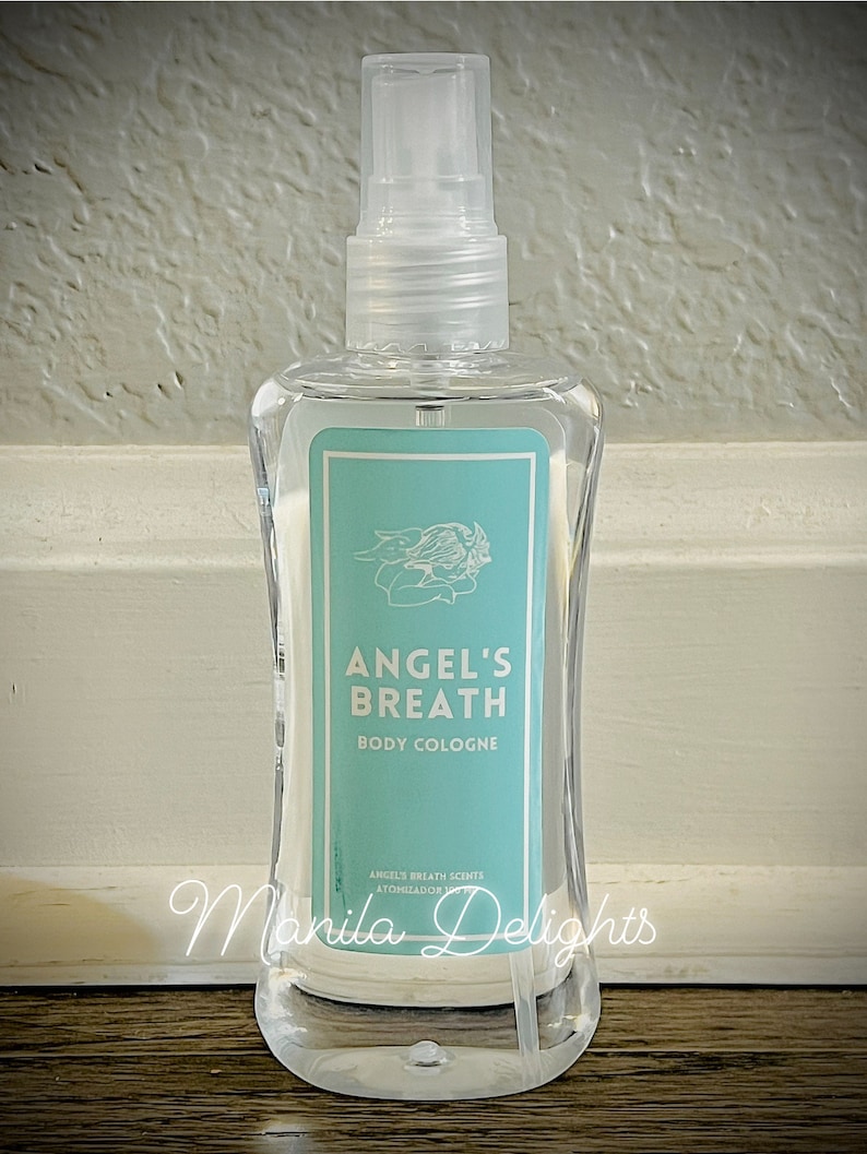 May include: A clear glass bottle of Angel's Breath body cologne. The bottle has a blue and white label with the text "Angel's Breath Body Cologne" and "Angel's Breath Scents Atomizador 237 ml."