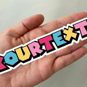May include: A sticker with the text "YOURTEXT" in a colorful, 3D-style font. The letters are outlined in black and have a white background.
