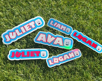 May include: A collection of five custom vinyl stickers featuring the names JULIET, LIAM, LOGAN, and AVA in bold red block letters with a bright blue outline. Each sticker includes a small, smiling cartoon face icon at the end of the name.