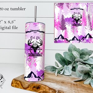 Peut inclure: Un design numérique rose et blanc pour un gobelet de 591 ml avec un crâne de cerf avec des bois, une cible et le texte "Girls Like Big Racks Too!" Le design comprend également une chaîne de montagnes et des arbres en arrière-plan.