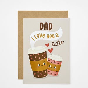 May include: A greeting card with a brown kraft paper envelope. The card features two cartoon coffee cups with heart patterns and the text "DAD I love you a latte". The cups have smiling faces and are set against a light beige background.