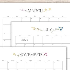 May include: A set of three printable calendar pages for the year 2027, featuring the months of March, July, and November. Each page displays a grid layout with days of the week, dates, and delicate watercolor floral illustrations above the month name.