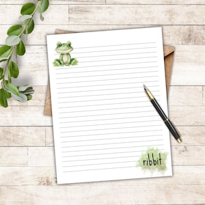 Peut inclure: Une feuille de papier lignée blanche avec une illustration de grenouille verte et le mot "ribbbit" en bas.