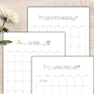 May include: Three white paper calendars with floral accents. The calendars display the months of April, September, and January 2026. Each calendar has a simple grid layout with days of the week and dates.