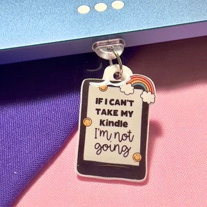 Può includere: Un portachiavi in plastica bianca a forma di tablet con il testo "If I can't take my Kindle I'm not going" e una grafica arcobaleno e nuvola.