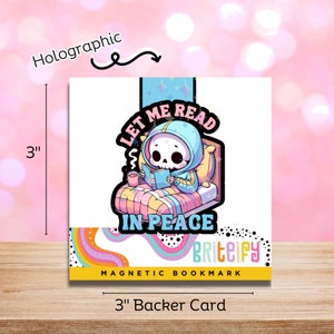 Puede incluir: Un marcapáginas magnético holográfico de 7,6 cm con un esqueleto de dibujos animados con una sudadera con capucha azul leyendo un libro en la cama. El marcapáginas tiene el texto "Let Me Read In Peace" y el nombre de la marca "Briteify".