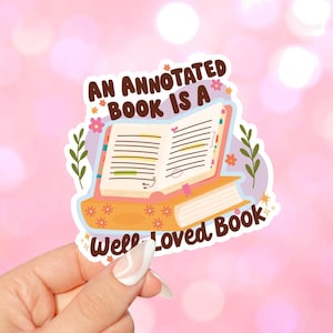 May include: A sticker featuring an open book with colorful flowers and the text "An Annotated Book is a Well Loved Book".