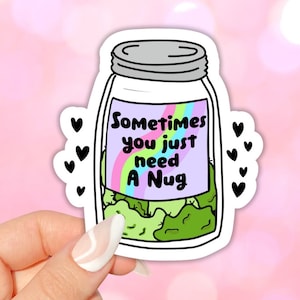 Puede incluir: Una pegatina de un tarro de cristal con un diseño de arcoíris y el texto "Sometimes you just need a Nug". El tarro está lleno de hierba verde.