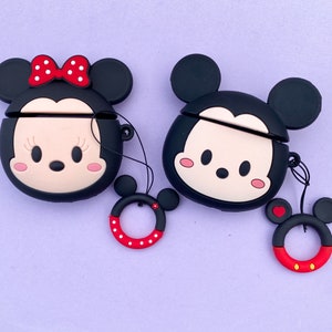 May include: Two black silicone phone cases with cartoon images of Mickey Mouse and Minnie Mouse. The cases have a small red heart charm attached to a black string.