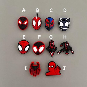 May include: Ten different Spider-Man themed shoe charms, each featuring a different design of the superhero in red, black, and white. The charms are labeled A through J.