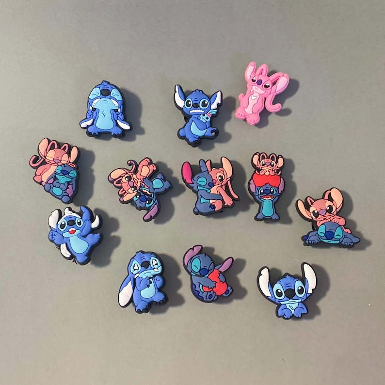 May include: A collection of 12 blue and pink cartoon character shoe charms featuring Stitch from the Disney movie Lilo & Stitch. The charms are made of plastic and have a variety of poses and expressions.