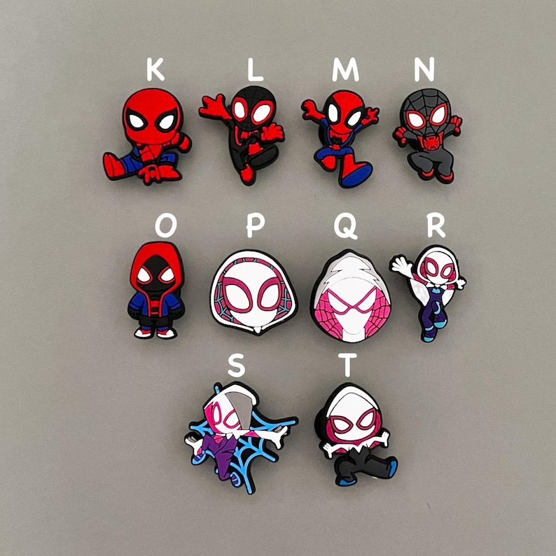 May include: Ten different shoe charms featuring Spider-Man characters. The charms are made of rubber and feature different poses and designs. The charms are labeled with letters K through T.