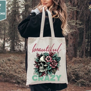 May include: A white tote bag with a skull and floral design. The text "beautiful crazy" is printed on the bag.