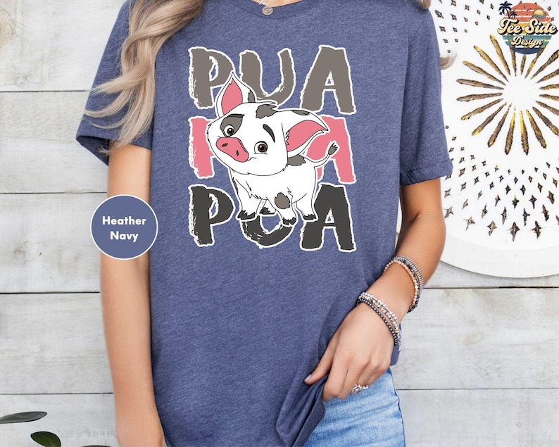 A person wearing a blue t-shirt with a cartoon pig graphic and text on it.