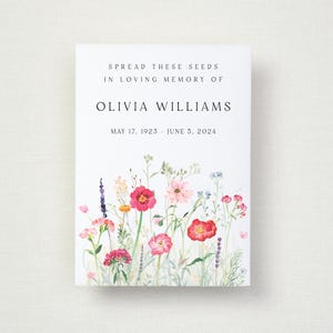 May include: A white card with the text "SPREAD THESE SEEDS IN LOVING MEMORY OF OLIVIA WILLIAMS" and dates "MAY 17, 1923 - JUNE 5, 2024". The bottom of the card features a watercolour illustration of colourful wildflowers.
