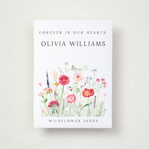 May include: A white card featuring the text "FOREVER IN OUR HEARTS" and "OLIVIA WILLIAMS" above a watercolour illustration of colourful wildflowers. The words "WILDFLOWER SEEDS" are at the bottom.
